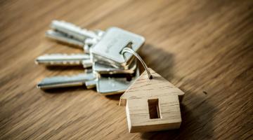 a set of silver keys with a wooden house keyring