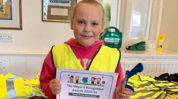 Young girl in hi vis holding certificate