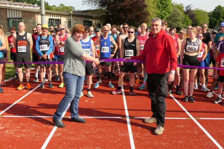 Councillor Anne Johnson with Tavistock Athletic Club's Alistair Kinsey, cutting the ribbon to officially open the resurfaced track.