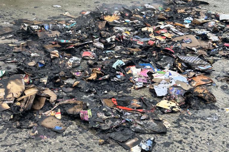 The remnants of recycling set on fire by a battery placed incorrectly in a recycling container.