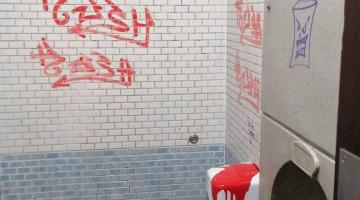 An example of vandalism in our public toilets - a series of orange graffiti tags sprayed on the wall of the toilets.