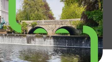 a green logo running through a river scene